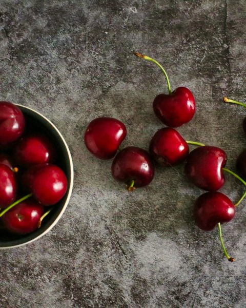 red cherries on black round plate