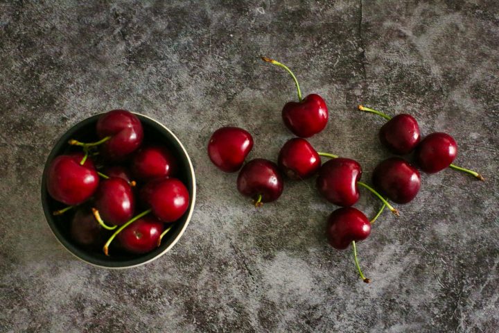 red cherries on black round plate