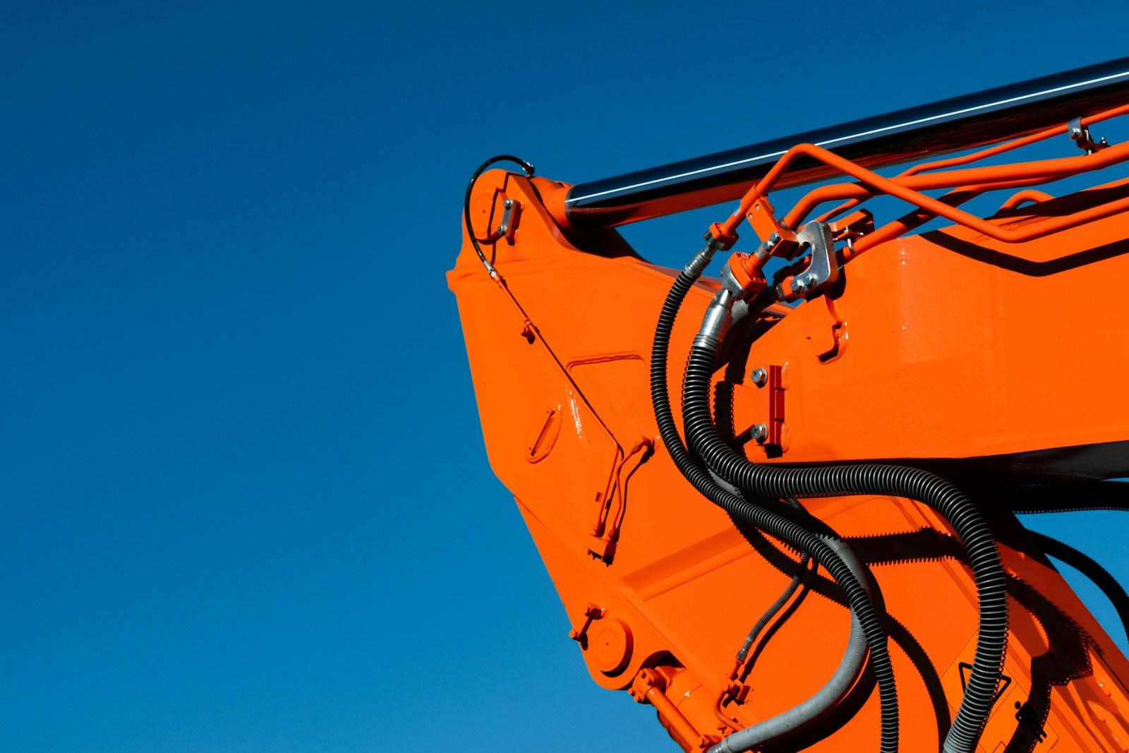 a close up of an orange crane with a sky background