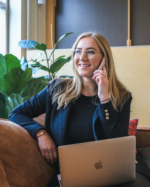 woman in blue long sleeve shirt using silver macbook