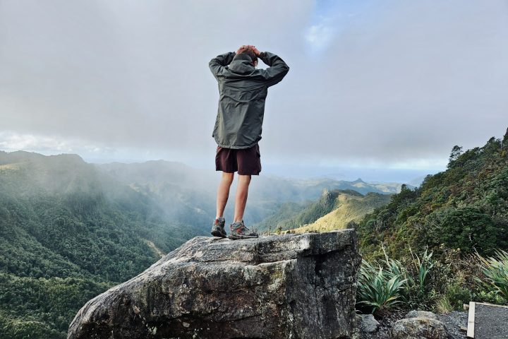 a man standing on top of a large rock