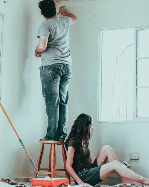 woman in gray t-shirt and blue denim jeans sitting on brown wooden seat