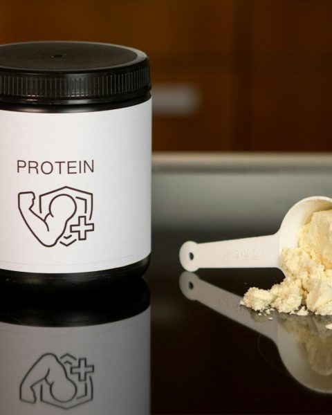 a container of protein powder next to a spoon