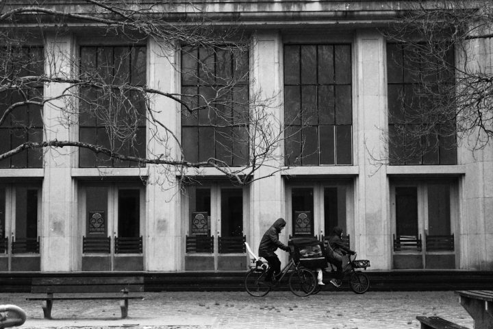 a person sitting on a bench in front of a building