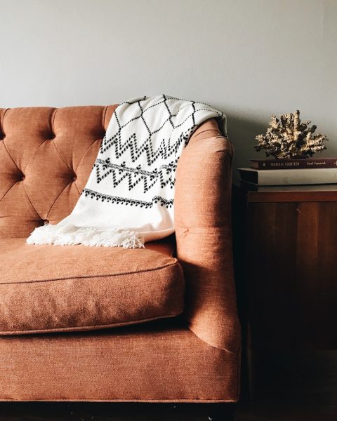 white and black textile on brown couch