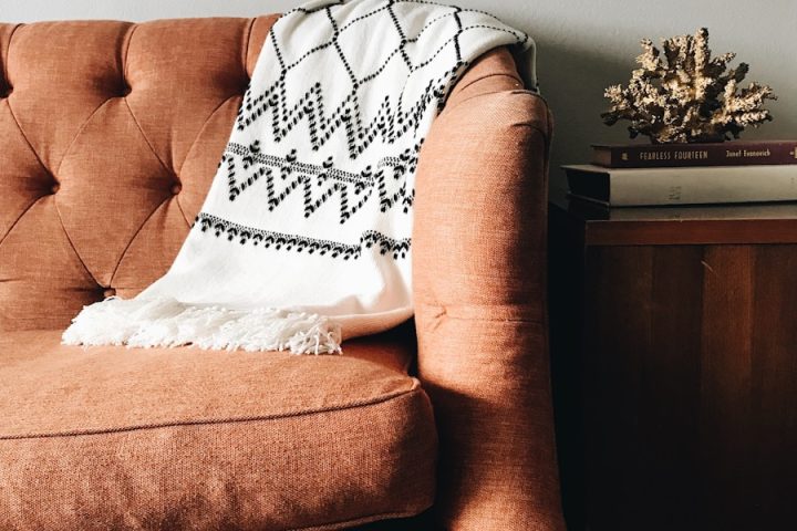 white and black textile on brown couch