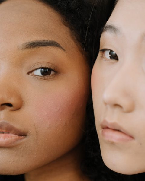 Close-up portrait of two women showcasing diverse beauty and natural skin.