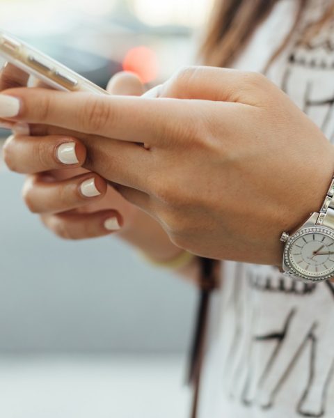 woman holding iPhone during daytime