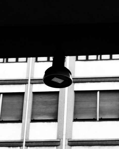 Black and white of a hanging light fixture and building