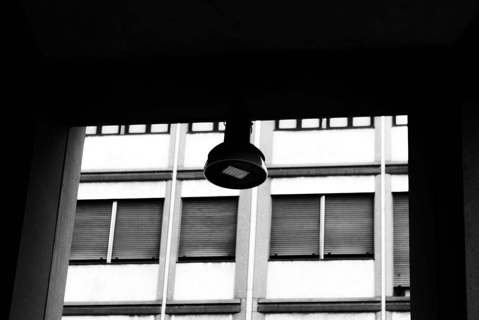 Black and white of a hanging light fixture and building