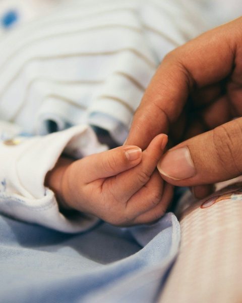 person holding baby's index finger