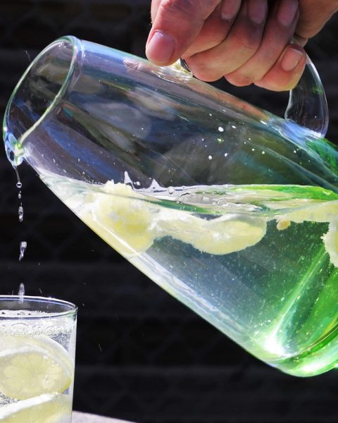 Kleurrijke alcoholvrije zomerdranken in glazen kannen met ijs en verse munt