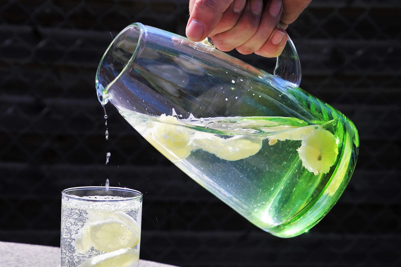 Kleurrijke alcoholvrije zomerdranken in glazen kannen met ijs en verse munt