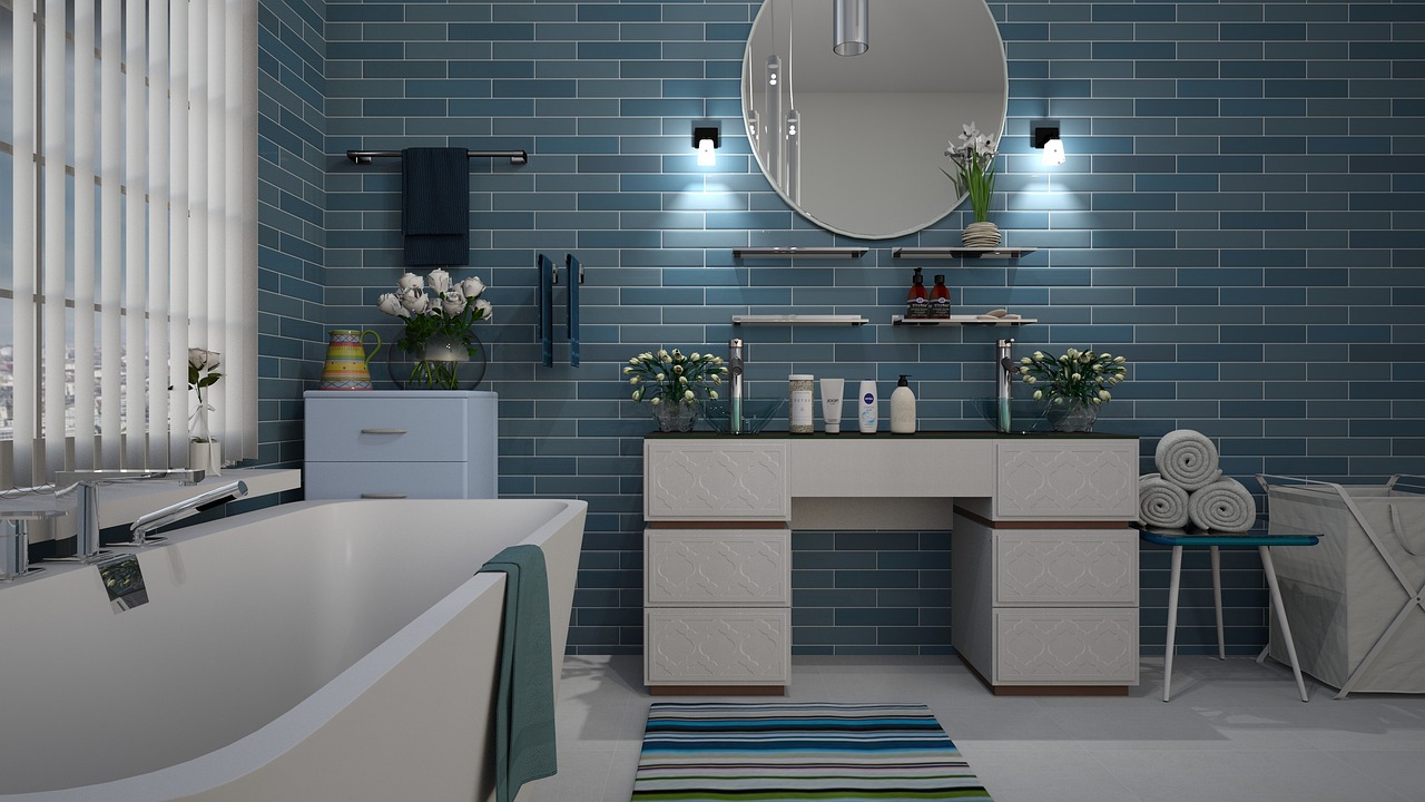 Elektrische handdoekradiator gemonteerd op een witte badkamermuur naast een douche