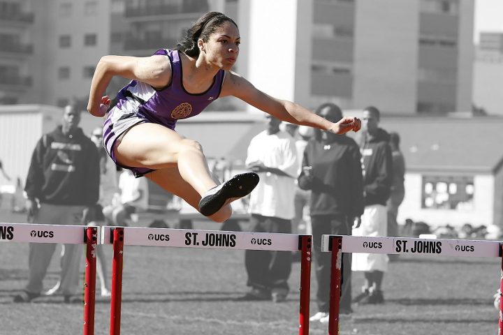Een vrouwelijke sprinter op een atletiekpiste tijdens een wedstrijd