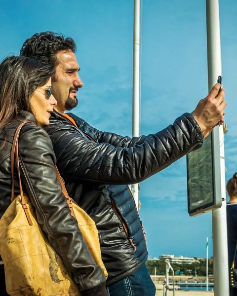 Persoon op het strand die belt met een smartphone tijdens vakantie