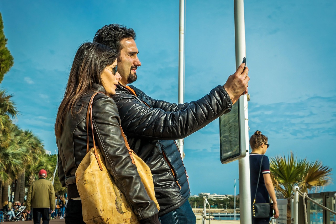 Persoon op het strand die belt met een smartphone tijdens vakantie