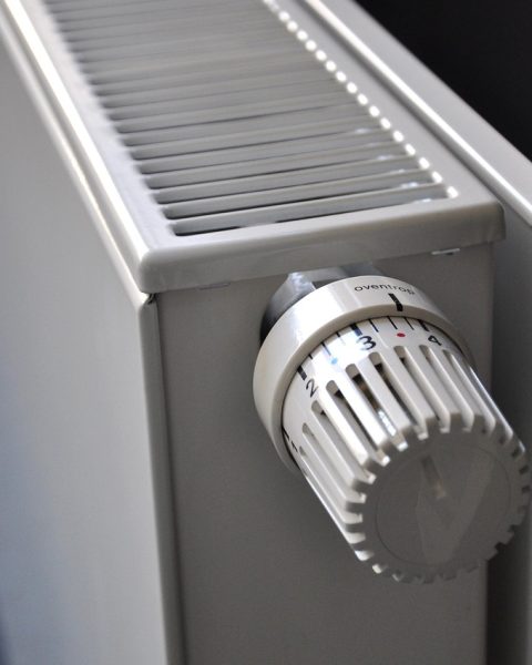 Een witte radiator aan een muur in een woonkamer