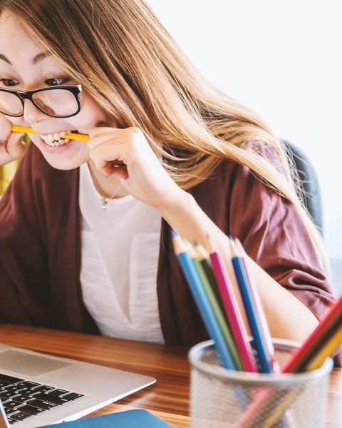 Persoon met bril die werkt achter een computerscherm op kantoor