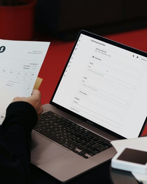 A person sitting at a desk with a laptop and papers