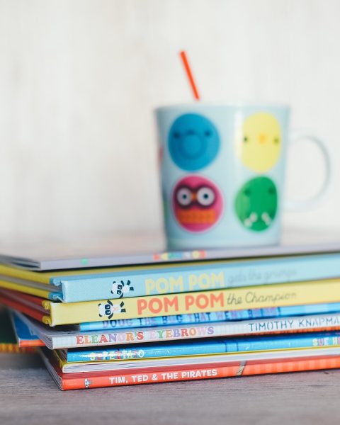 Kinderen die vrolijk zitten te lezen in kleurrijke boeken
