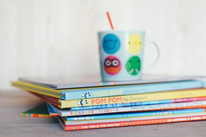 Kinderen die vrolijk zitten te lezen in kleurrijke boeken