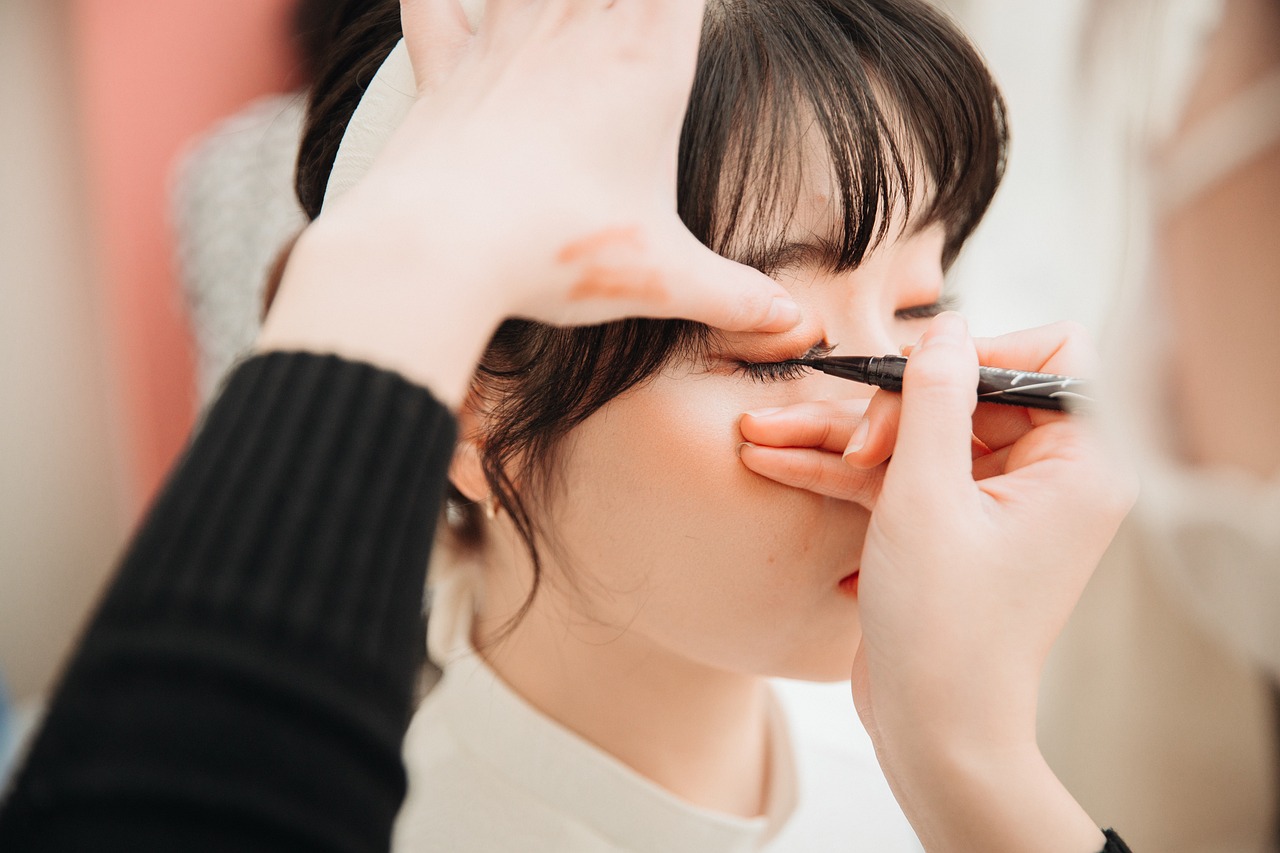 Vrouw brengt eyeliner aan voor een spiegel op een toilettafel