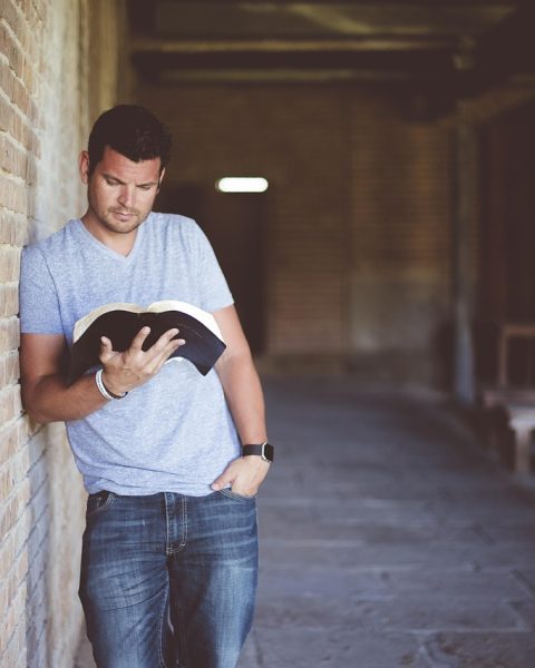 Een volwassene leest een boek op de bank, verdiept in een verhaal