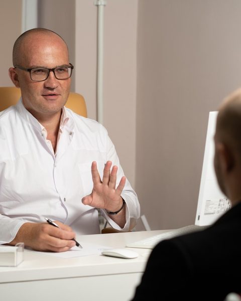 Arts en patiënt in gesprek in een medische spreekkamer