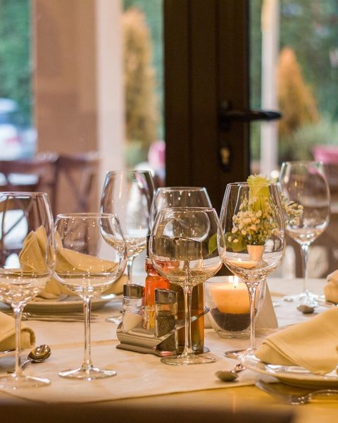 Gedekte restauranttafel met kaarsen en herfstdecoratie voor een seizoensdiner