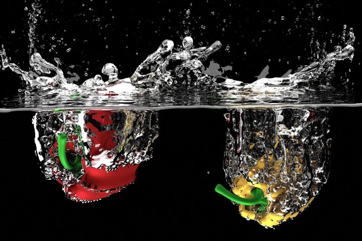 Een tafel met groenten, peulvruchten en een glas water als symbool voor niervriendelijke voeding