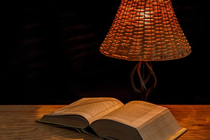Iemand leest een thriller bij nachtlampje in bed